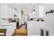 Bright modern kitchen featuring white cabinets and stainless appliances connected to a dining area and open floor plan to the upstairs at 305 Duel Ct., Myrtle Beach, SC 29588