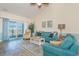 Bright living room with teal sofas, wood flooring, and balcony access at 4837 Luster Leaf Circle # 403, Myrtle Beach, SC 29577