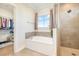 Bright bathroom featuring a soaking tub, walk-in shower, and an organized walk-in closet at 76 Eagle Pass Dr., Murrells Inlet, SC 29576