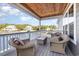 Covered porch features wicker furniture, overlooks beautiful lake and neighborhood at 76 Eagle Pass Dr., Murrells Inlet, SC 29576