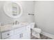Half bathroom features a toilet, sink, and a round mirror hanging over the sink at 1201 Surf Pointe Dr., North Myrtle Beach, SC 29582