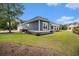 Exterior view of home showcasing the blue siding, stone foundation, manicured lawn, and a well-kept landscape at 1201 Surf Pointe Dr., North Myrtle Beach, SC 29582