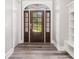 Bright foyer featuring a wood-look floor, elegant front door, and built-in shelving unit at 1201 Surf Pointe Dr., North Myrtle Beach, SC 29582