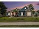 Charming home exterior features a stone facade, blue siding, lush lawn, and inviting entrance at 1201 Surf Pointe Dr., North Myrtle Beach, SC 29582