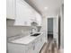 Kitchen featuring white cabinets, marble countertops, and stainless steel sink at 1201 Surf Pointe Dr., North Myrtle Beach, SC 29582
