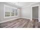Well-lit living room with plank flooring, white trim, modern light fixture, and plantation shutters at 1201 Surf Pointe Dr., North Myrtle Beach, SC 29582