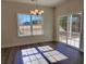 Bright dining room with a chandelier, showcasing natural light and views through a large window and sliding glass door at 2770 Daisy Rd., Loris, SC 29569