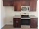 Close-up of kitchen area highlighting stainless steel appliances and dark wood cabinetry with granite countertops at 2770 Daisy Rd., Loris, SC 29569