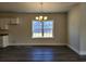 Open dining area with dark wood floors, a modern chandelier, and a large window at 2808 Daisy Rd., Loris, SC 29569
