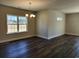 Bright dining area with dark wood floors, a chandelier, and natural light from the window at 2808 Daisy Rd., Loris, SC 29569