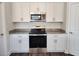 Well-lit kitchen features stainless steel appliances, speckled granite countertops, and modern white cabinets at 2808 Daisy Rd., Loris, SC 29569