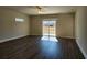 Open-concept living room boasts wood floors, a ceiling fan, and a sliding glass door to the backyard at 2808 Daisy Rd., Loris, SC 29569