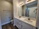 Bathroom featuring double sink vanity, modern fixtures, large mirror and wood look flooring at 2814 Daisy Rd., Loris, SC 29569