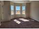 Bright bedroom featuring natural light from three windows, neutral walls, and plush carpeting at 2814 Daisy Rd., Loris, SC 29569