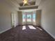 Spacious bedroom with a tray ceiling, three windows, neutral walls, and plush carpeting at 2814 Daisy Rd., Loris, SC 29569