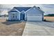 Charming single-story home with blue siding, a two-car garage, and a well-manicured lawn at 2814 Daisy Rd., Loris, SC 29569