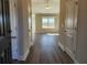 Inviting hallway featuring wood floors and an open view to a sunlit living area with large windows at 2814 Daisy Rd., Loris, SC 29569