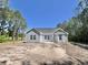 The back of a charming single-story home is visible under a clear blue sky with some trees at 6944 Highway 66, Loris, SC 29569