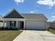 Charming one-story home with a two-car garage and manicured lawn, set beneath a bright blue sky at 189 Ashworth Dr., Tabor City, NC 28463