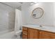 Bright bathroom with wood vanity, round mirror, and shower-tub combo at 2053 Haystack Way, Myrtle Beach, SC 29579