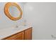 Half bath featuring a round, wood-trimmed mirror and a vanity with dark wood cabinets at 2053 Haystack Way, Myrtle Beach, SC 29579