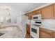 Bright kitchen features white appliances, wood cabinets and granite countertops with subway tile backsplash at 2053 Haystack Way, Myrtle Beach, SC 29579