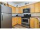 Modern kitchen with stainless steel appliances and wood cabinets at 2405 S Ocean Blvd. # 207, North Myrtle Beach, SC 29582