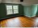 Spacious bedroom with hardwood floors, large windows, and light green painted paneled walls at 2708 Main St., Loris, SC 29569