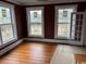 Bedroom with hardwood floors, three windows, and freshly painted walls at 2708 Main St., Loris, SC 29569