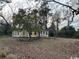 Charming yellow home with a welcoming porch surrounded by mature trees on a dry lawn at 2708 Main St., Loris, SC 29569