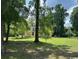 Charming yellow home with a welcoming porch, nestled among mature trees on a sprawling green lawn at 2708 Main St., Loris, SC 29569