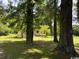 Charming yellow home with a welcoming porch, nestled among mature trees on a private lawn at 2708 Main St., Loris, SC 29569