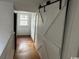 Hallway with hardwood floors and a white barn door at 2708 Main St., Loris, SC 29569