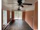 A view of the covered porch with sliding glass doors, brick feature, and orange paneled walls at 2708 Main St., Loris, SC 29569