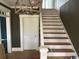 Interior staircase with white wainscoting and trim and stained wood steps at 2708 Main St., Loris, SC 29569