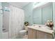 Bright bathroom with a combination tub and shower, decorative floral shower curtain, and a light wood vanity at 352 Mckendree Ln., Myrtle Beach, SC 29579