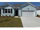 Charming single-story home featuring a blue exterior, attached garage, and well-manicured lawn at 556 Duvall St., Longs, SC 29568