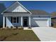 Charming single-story home with light blue siding, well-manicured lawn, and attached two-car garage at 564 Duvall St., Longs, SC 29568