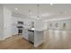 Open kitchen features a center island, stainless steel appliances, pendant lighting, and wood-look flooring at 1200 Nw Calabash Station Blvd., Calabash, NC 28467