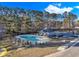Community pool area with lounge chairs, a fenced-in pool, and a bathhouse surrounded by tall trees at 1200 Nw Calabash Station Blvd., Calabash, NC 28467