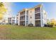 Low angle shot of a light yellow apartment building with screened in balconies and a well-maintained lawn at 1310 River Oaks Dr. # 2J, Myrtle Beach, SC 29579