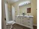 Bright bathroom featuring a double sink vanity, a walk-in shower with curtain and wood-look flooring at 306 E Godbold St., Marion, SC 29571