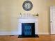 Close-up of fireplace with mantel, decorative clock, and painted screen at 306 E Godbold St., Marion, SC 29571