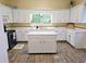 Kitchen featuring white cabinets, tile countertops, an island, and wood-look flooring at 306 E Godbold St., Marion, SC 29571