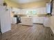 Kitchen featuring white cabinets, an island, appliances, and wood-look flooring at 306 E Godbold St., Marion, SC 29571