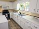 Kitchen featuring white cabinets, tile countertops, stainless appliances, and a garden window at 306 E Godbold St., Marion, SC 29571