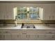 Kitchen featuring white cabinets, tile countertops, and a garden window with natural light at 306 E Godbold St., Marion, SC 29571