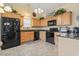 Well-lit kitchen with wooden cabinets, granite countertops, and black appliances at 1133 Spalding Ct., Surfside Beach, SC 29575