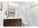 Well-lit bathroom with dark wood vanity, white countertops, shower with curtain, and large mirror at 3126 White Jasmine Dr., Little River, SC 29566