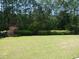 Spacious backyard with lush green lawn, mature trees and colorful foliage providing privacy and a serene outdoor space at 64 Summerlight Dr., Murrells Inlet, SC 29576